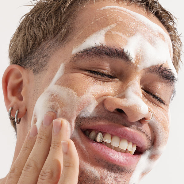 Happy man using About Time We Met's foaming cleanser