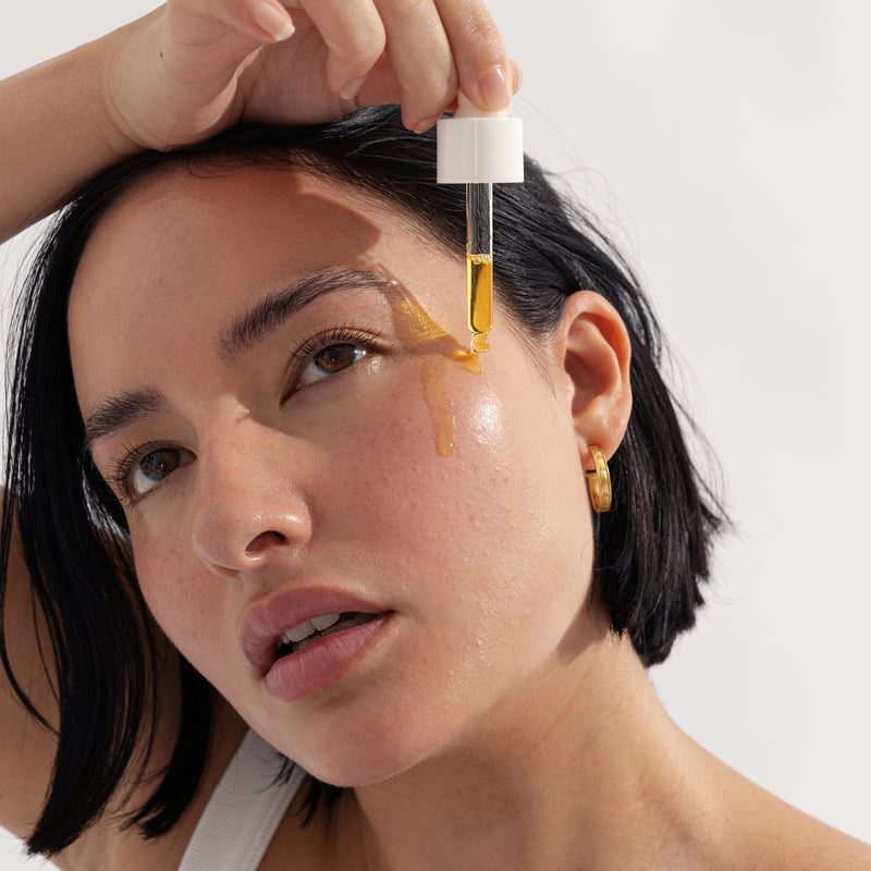 young female applying About time we met's radiance serum on hydrated face